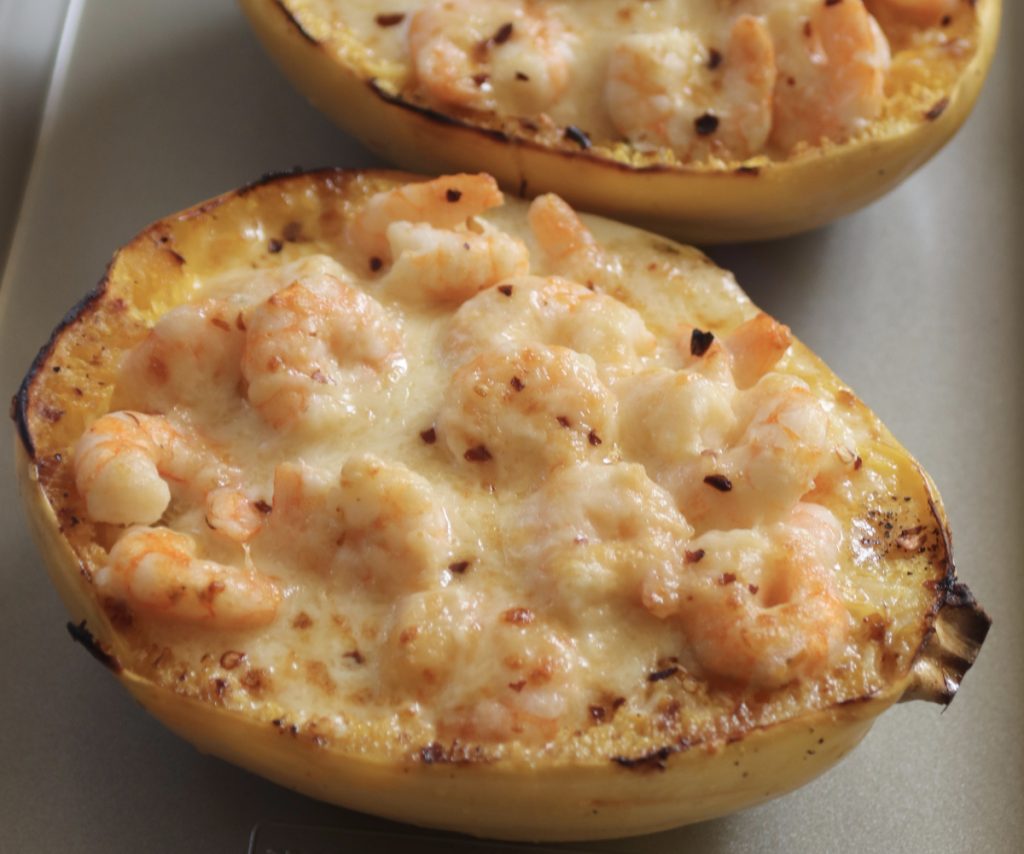 Creamy Shrimp Alfredo Spaghetti squash on a metal sheet pan. The pan is on a gray and white striped hand towel.