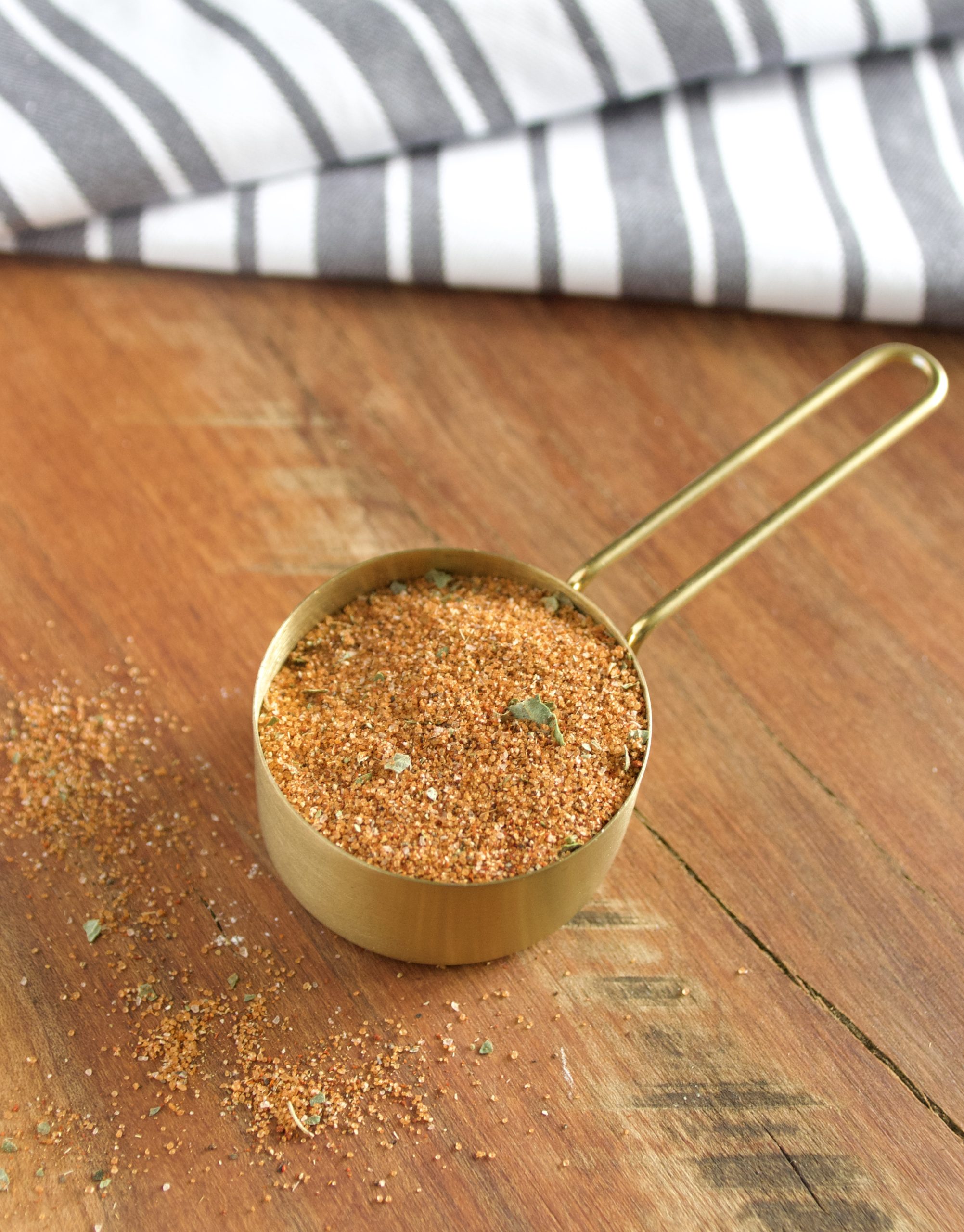 bbq rub in a gold measuring cup.