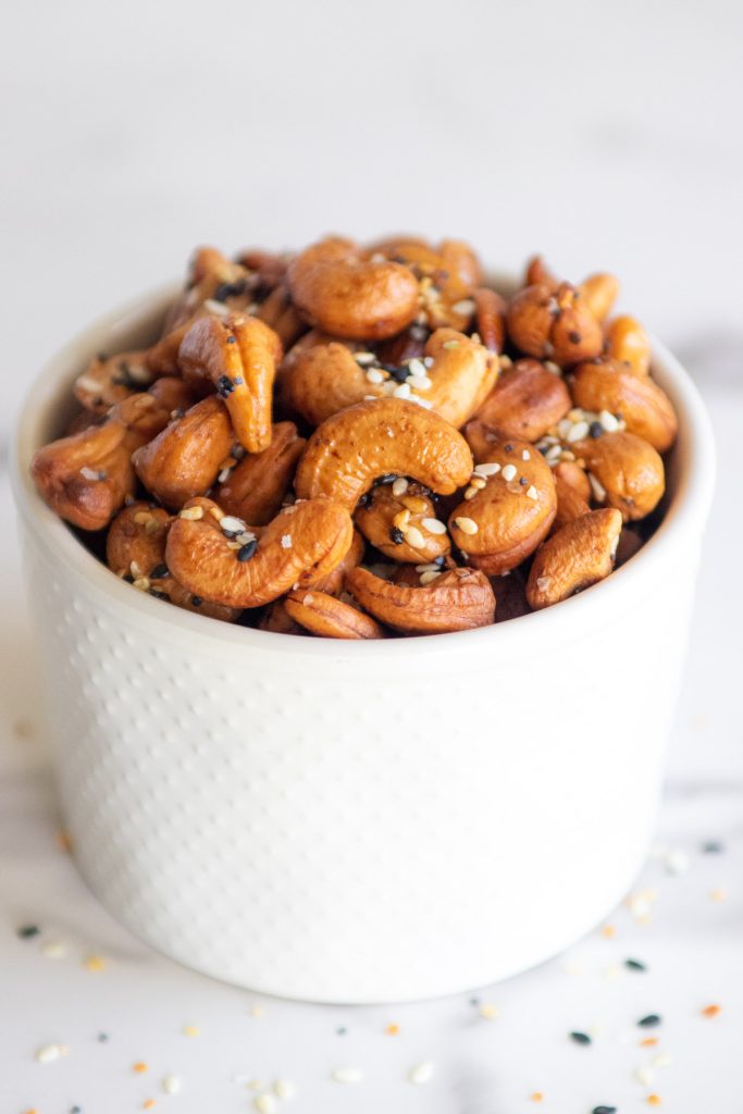 Everything bagel cashews in a white ramekin.