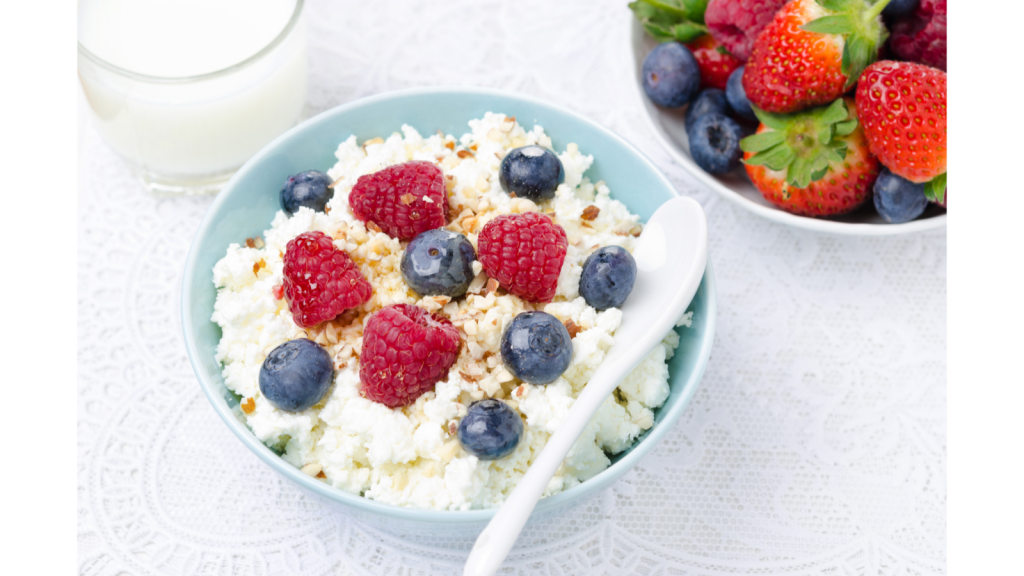 Cottage cheese in a bowl topped with nuts and berries.  