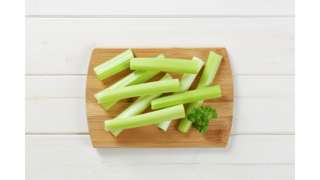 Celery sticks on a wood board.