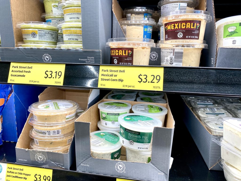 Containers of dip on a grocery store shelf.