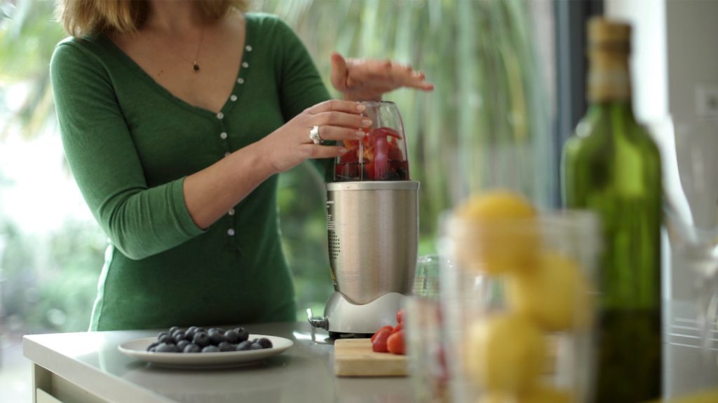 person making a smoothie in a blender. 