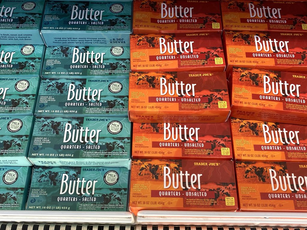 Cartons of butter in grocery store refrigerated case.