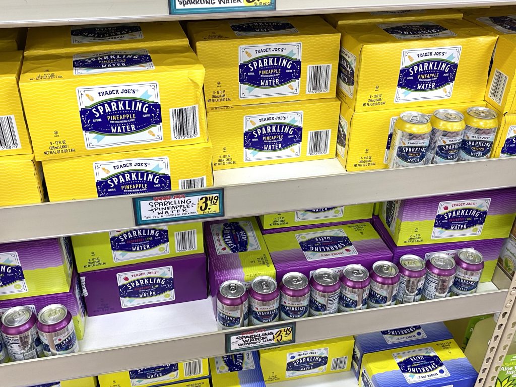 Cases of sparkling water on a grocery store shelf.