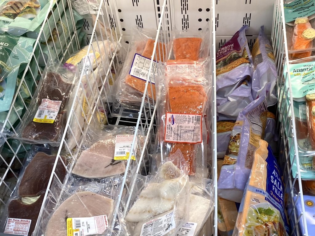 Seafood in grocery store frozen case.