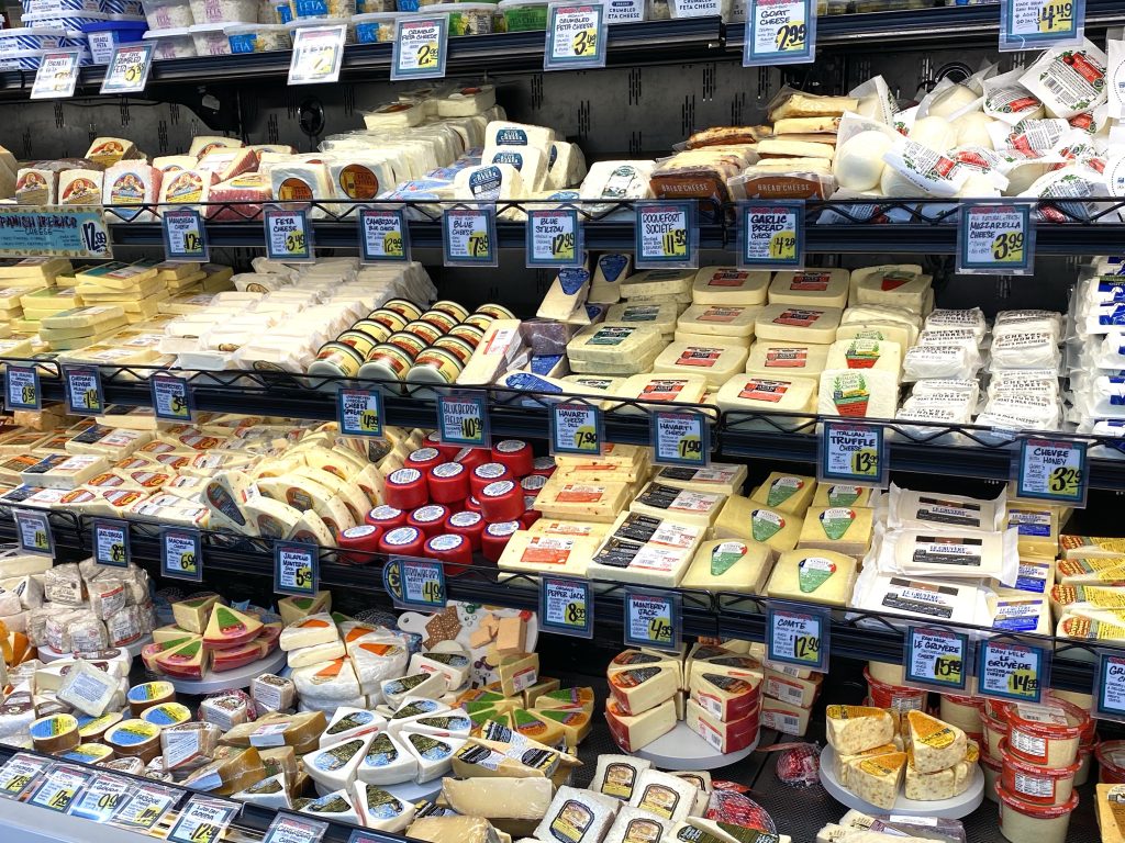 variety of cheese in the refrigerated grocery store case.
