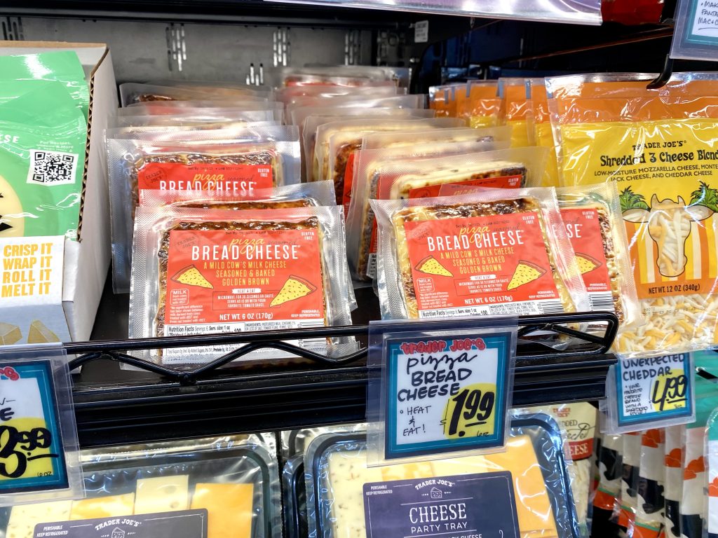 Bread cheese in refrigerated case at grocery store.
