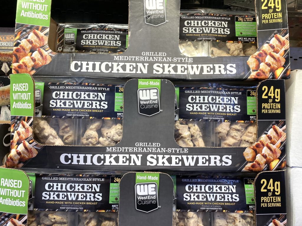 Chicken skewers on grocery shelf.