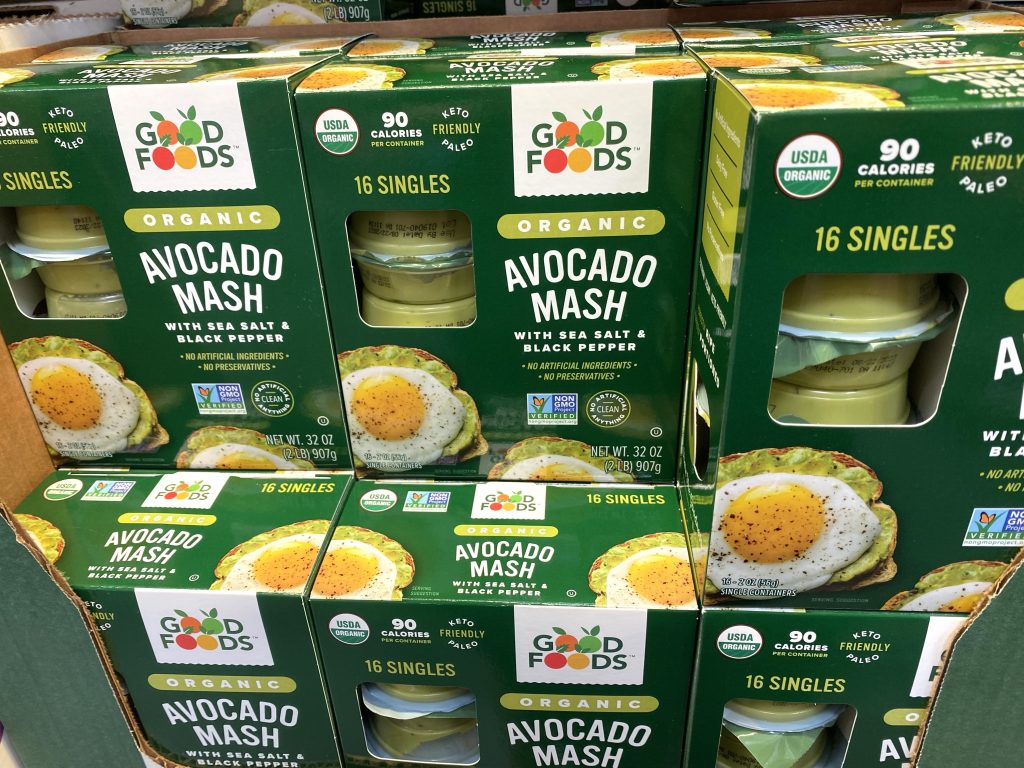 Mashed avocado cups on grocery shelf.