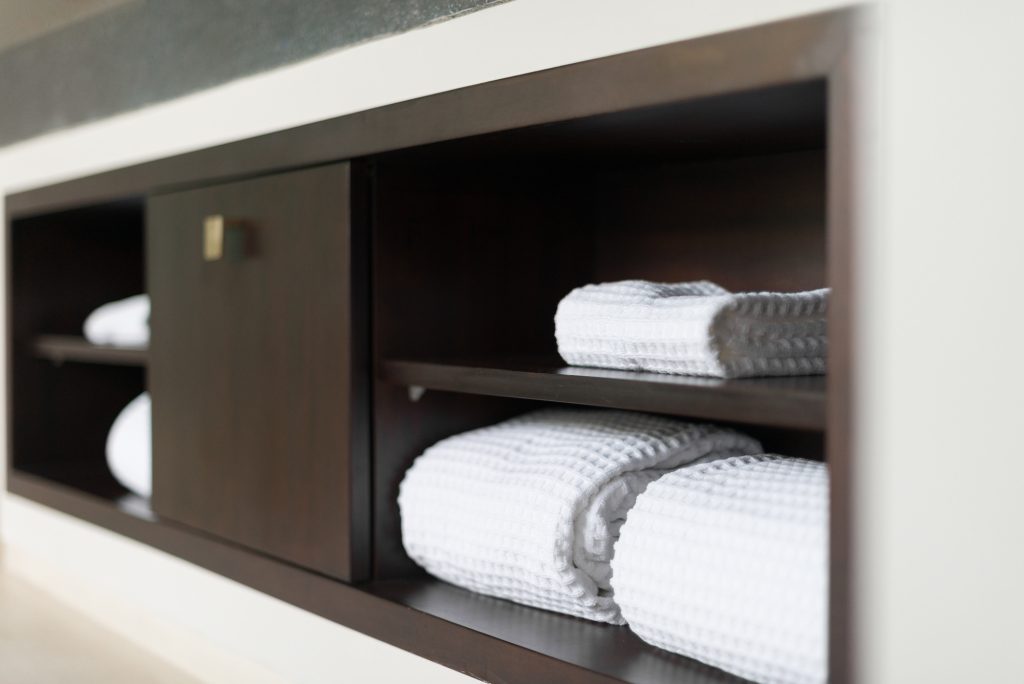 White towels on the shelf in a hotel bathroom.