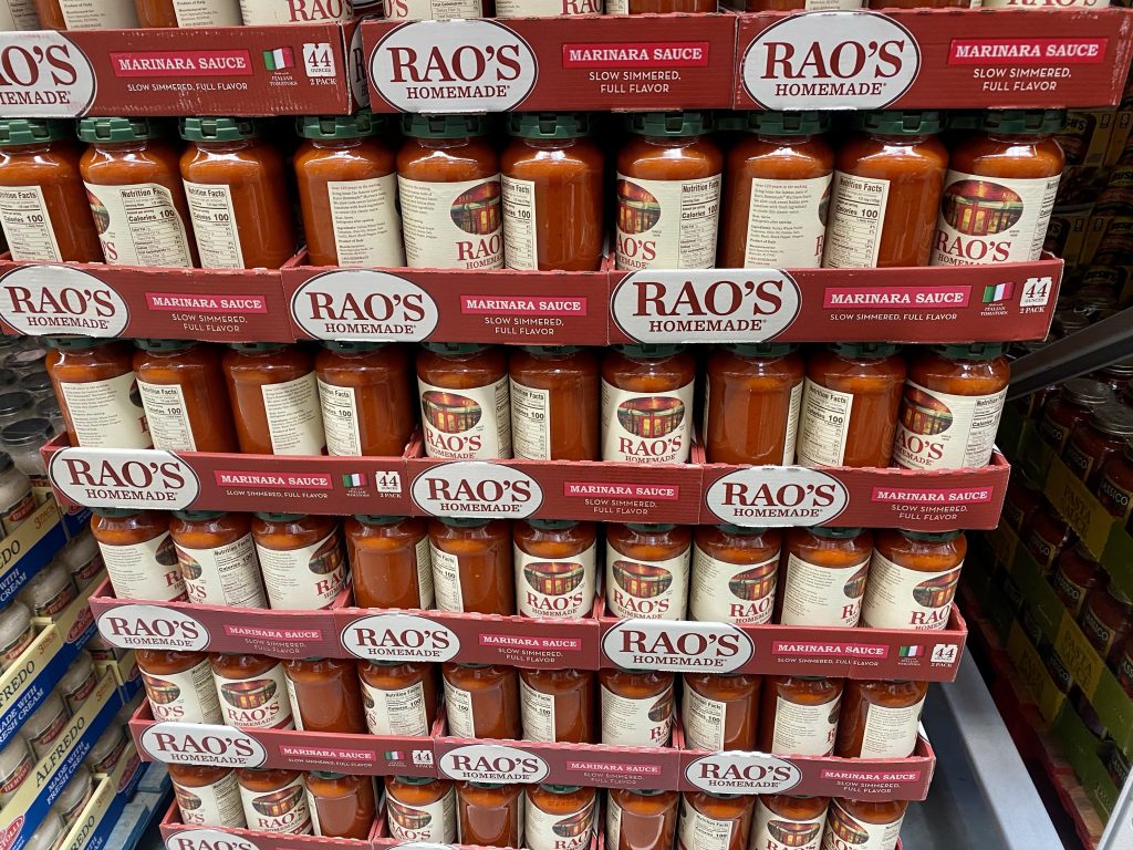 Stacks of Bottles of marinara sauce on grocery shelf.