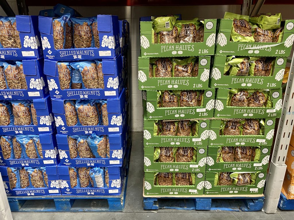 Large Packages of nuts in cartons on grocery shelf.