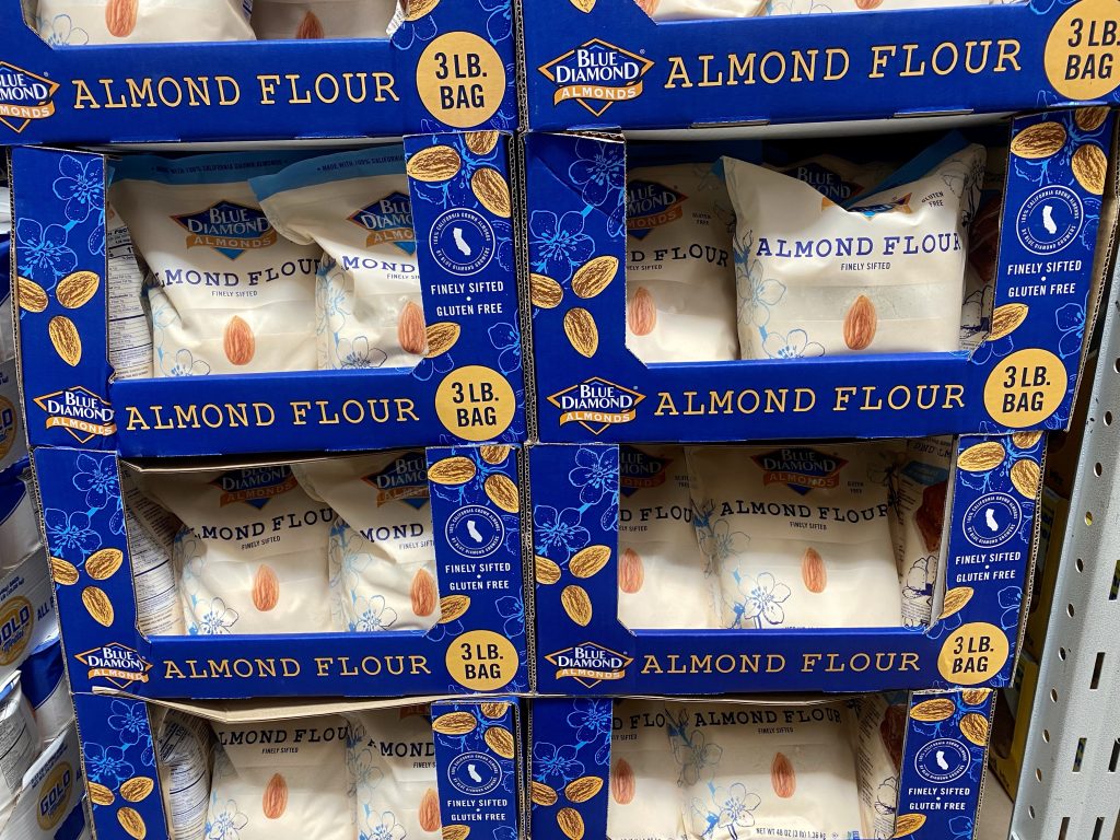 Packages of almond flour on grocery shelf.
