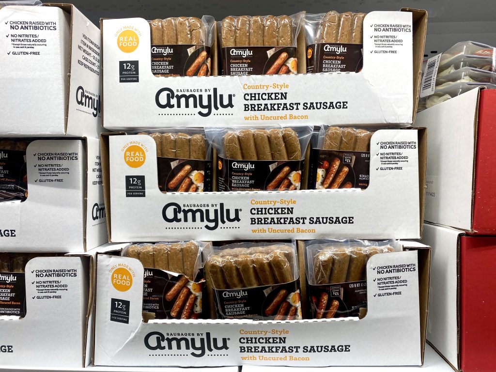 Chicken sausages on grocery shelf.