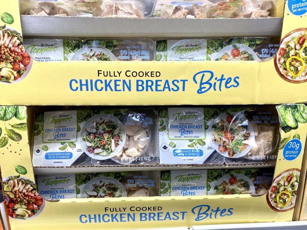 Fully cooked individual packages of chicken bites on grocery shelf.