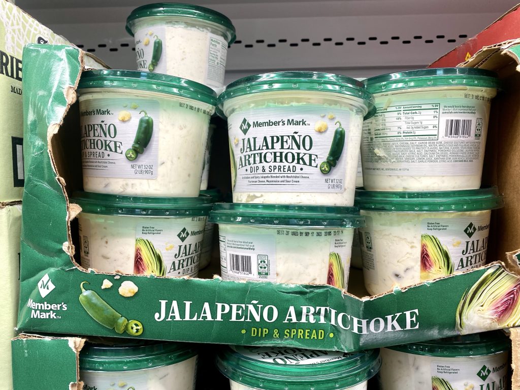Containers of jalapeno dip on the grocery shelf. 