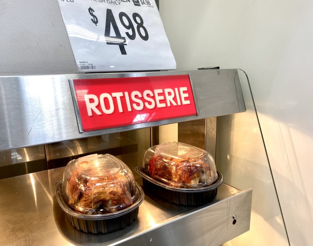Rotisserie chicken in warmer at grocery.