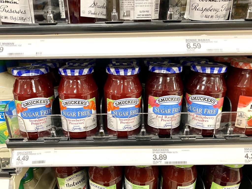 Jars of sugar free jelly on store shelf.