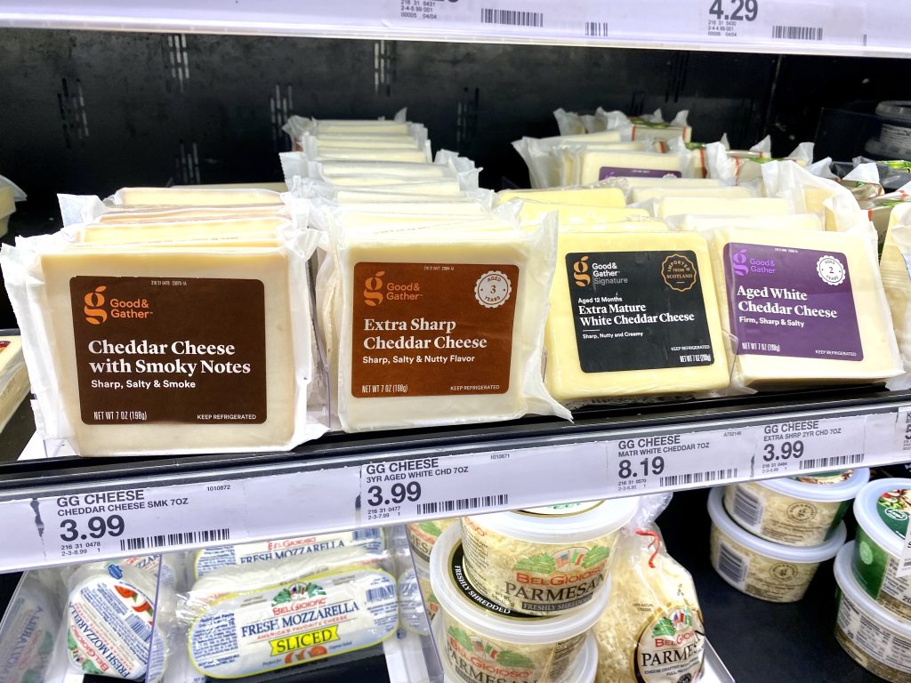 Packages of cheese on grocery store shelf.