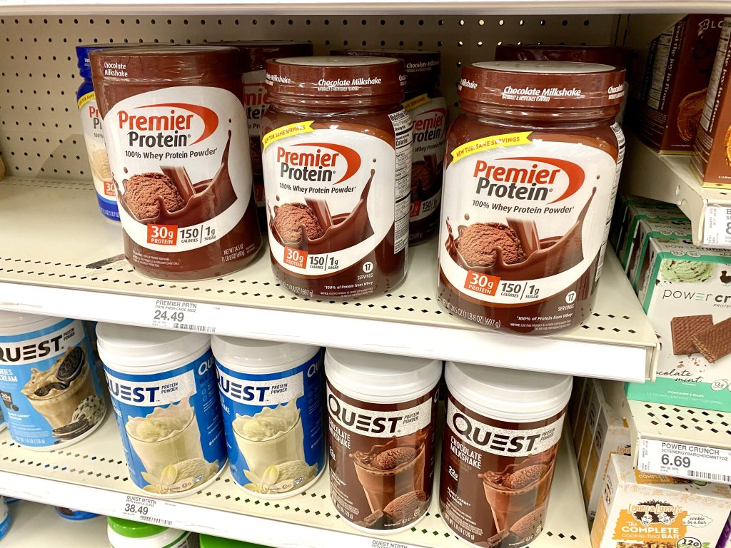 Containers of protein powder on store shelf.