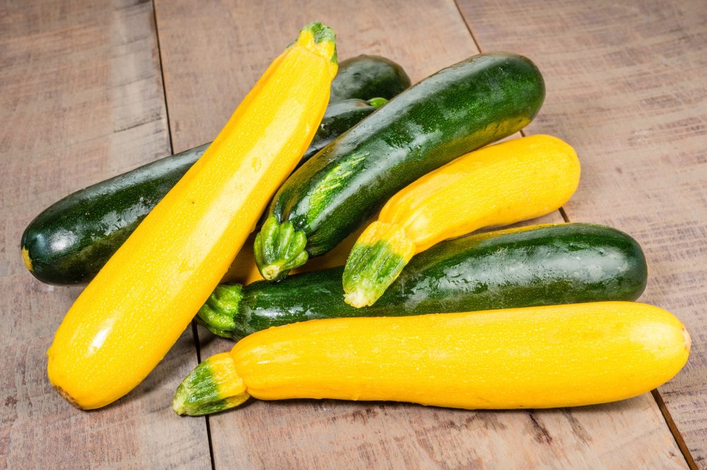 Zucchini and yellow squash on a wood backdrop.