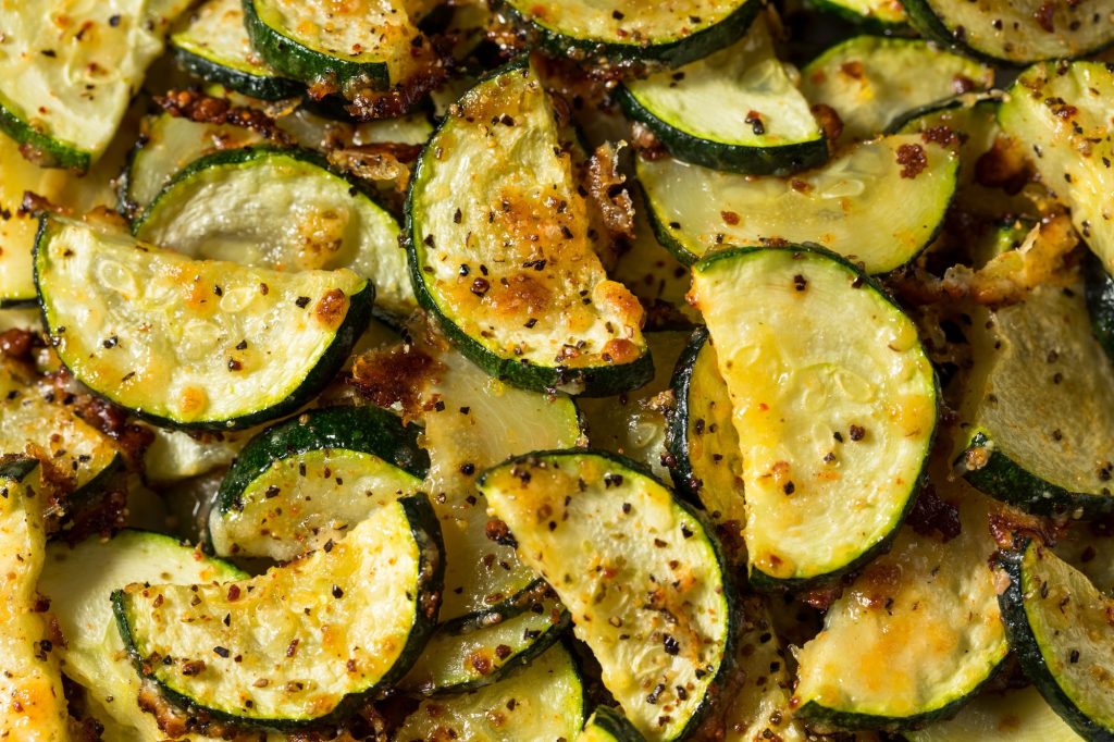 Roasted zucchini with cheese melted on top.