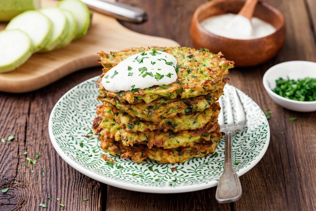 Zucchini fritters on a green patterned plate.