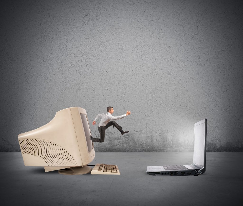 A generated image of a man jumping from an older vintage desktop computer into a newer laptop computer.