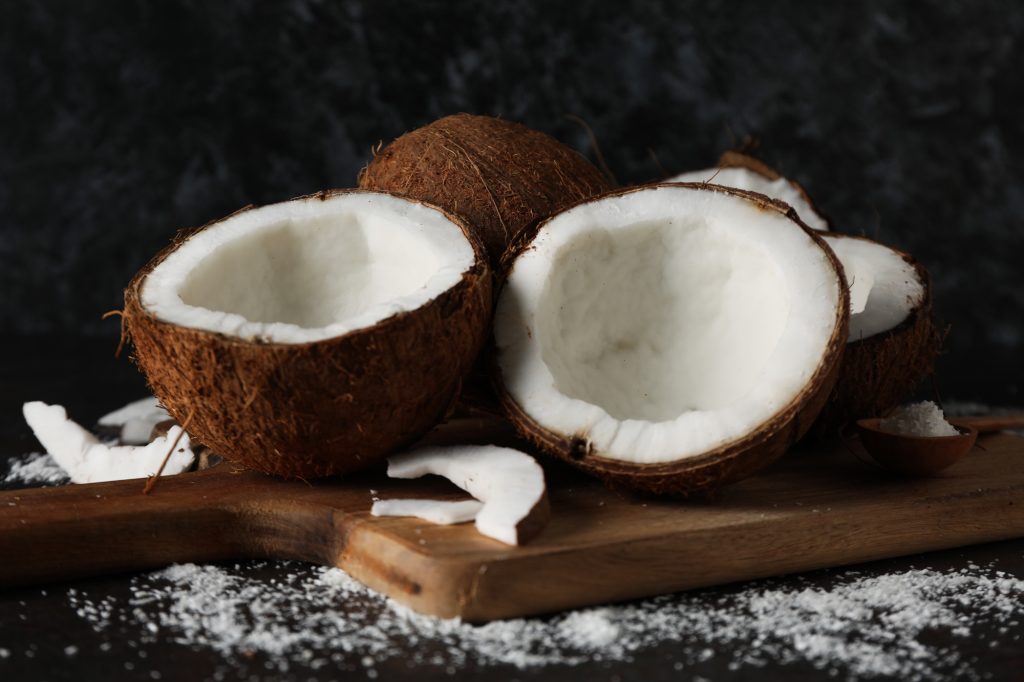 a coconut cut open. Some of the flesh is scooped out.