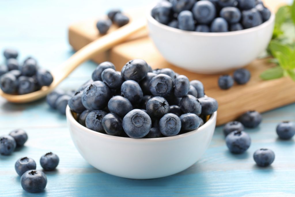 two white bowls full of blueberries.