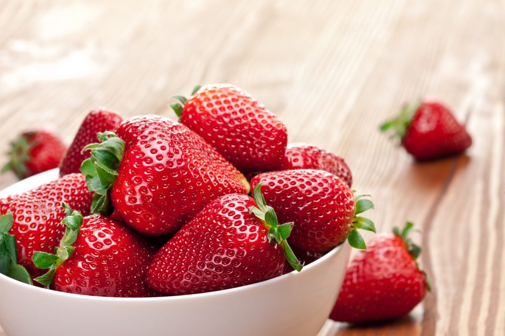 A white bowlful of strawberries.