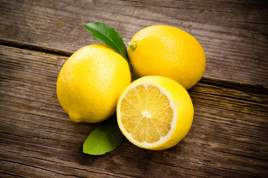 two lemons. One lemon is cut in half.