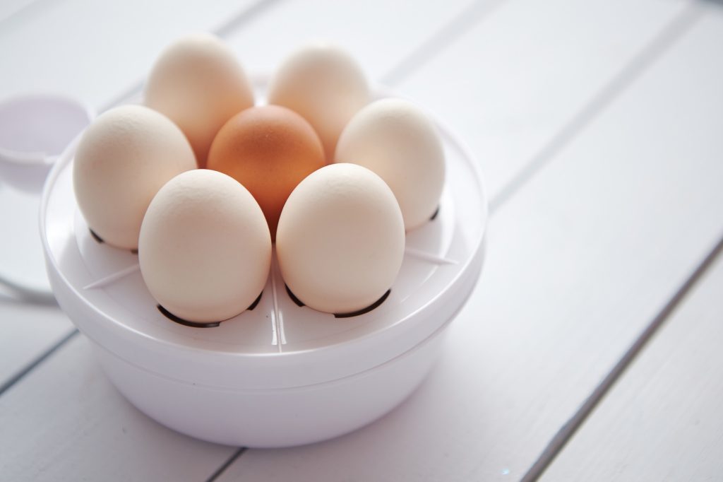 Egg cooker with seven eggs in it.