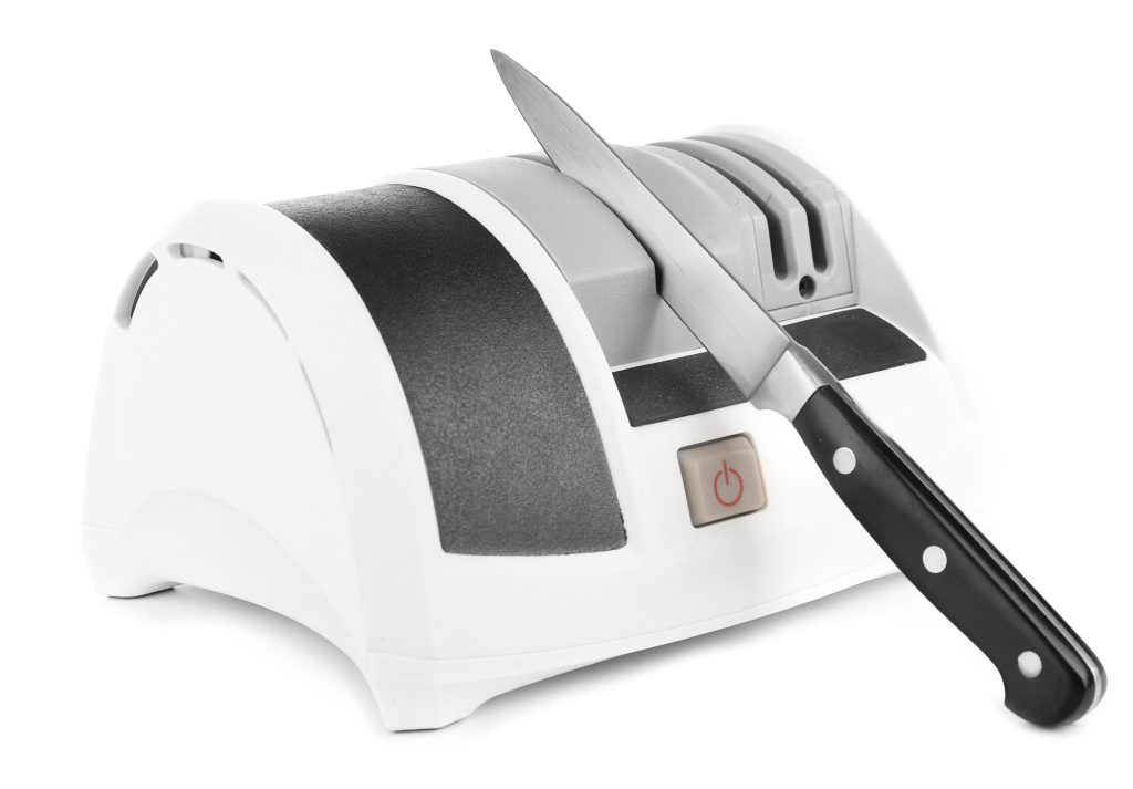 Electric knife sharpener with a knife sticking in one of the slots.