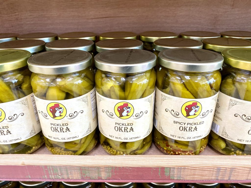 Jars on pickled okra on a store shelf.