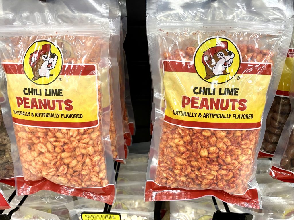 Packages of chili lime peanuts on store shelf.