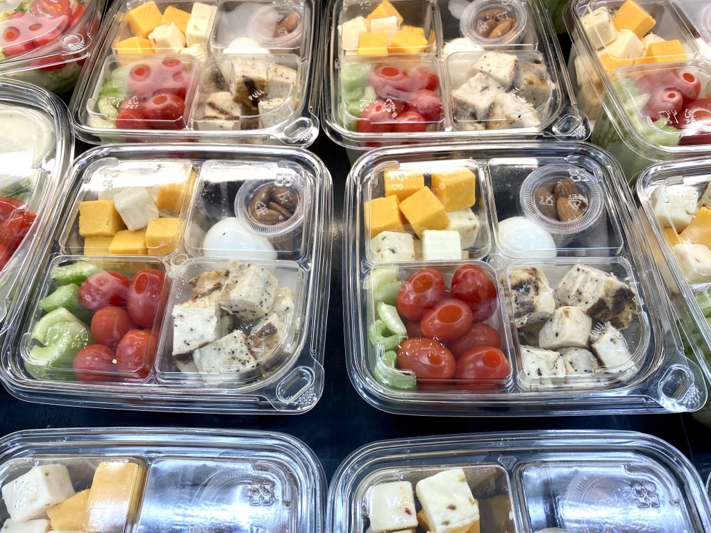 Boxes of cheese, meats, hard boiled eggs and nuts, they say keto box on the bottom.