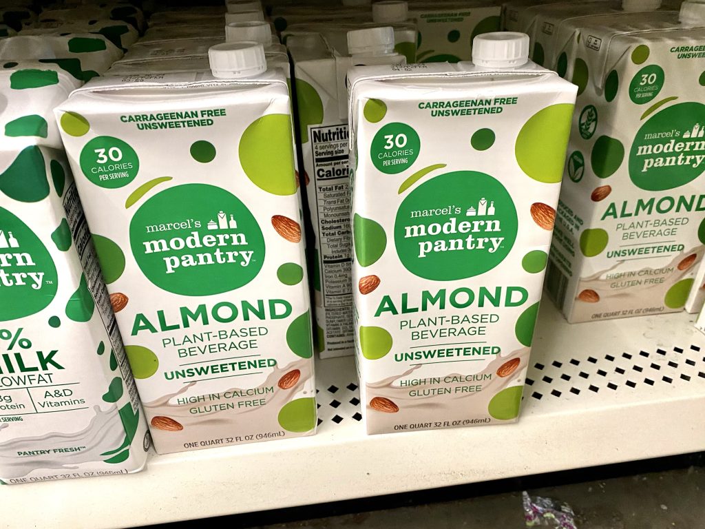 Boxes of unsweetened almond milk on a store shelf.