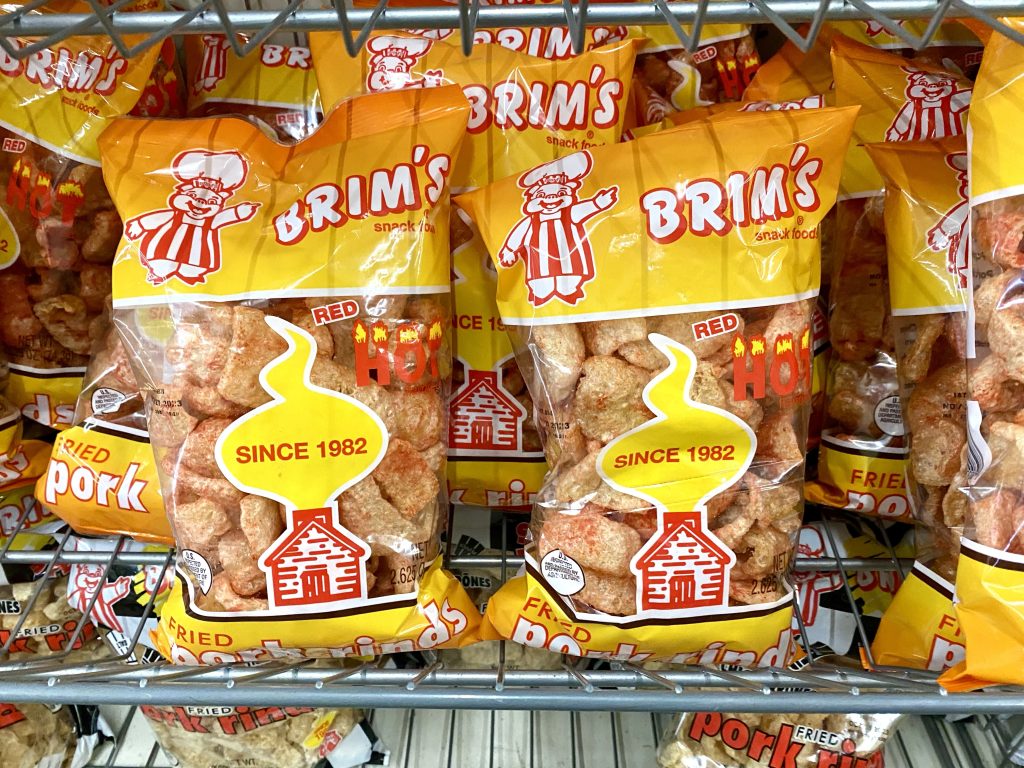 Bags of pork rinds on a store shelf.