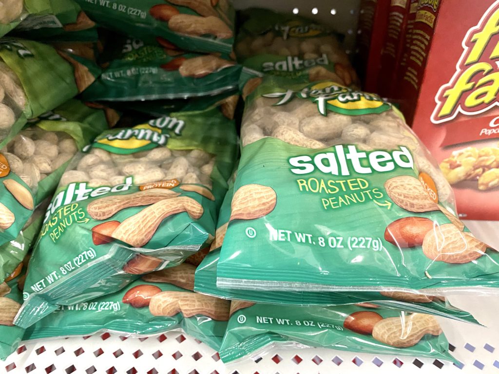 Bags of whole salted peanuts on a store shelf.