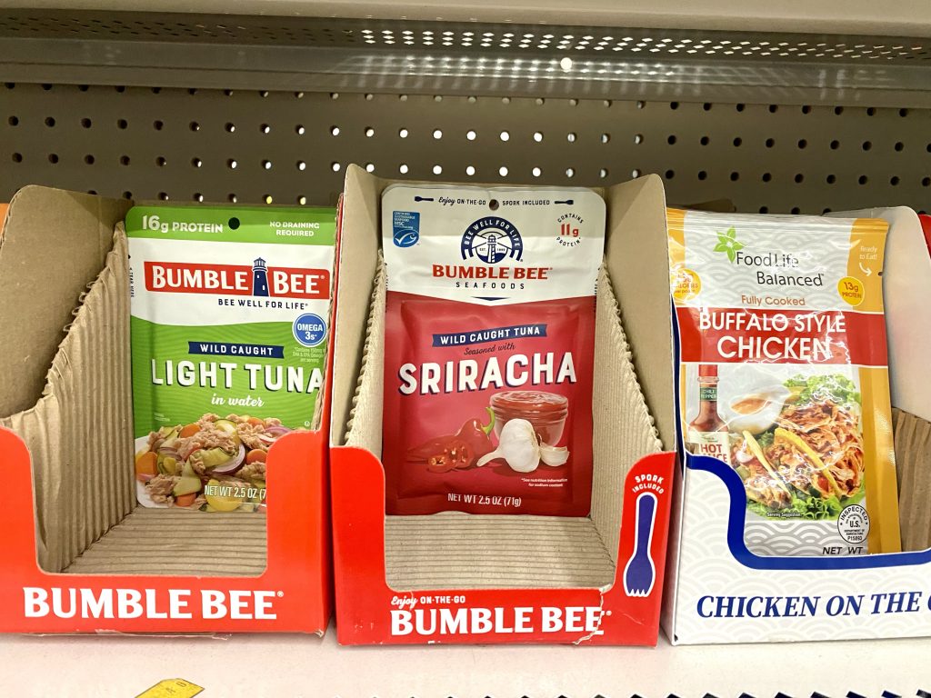 Packets of tuna on a store shelf.