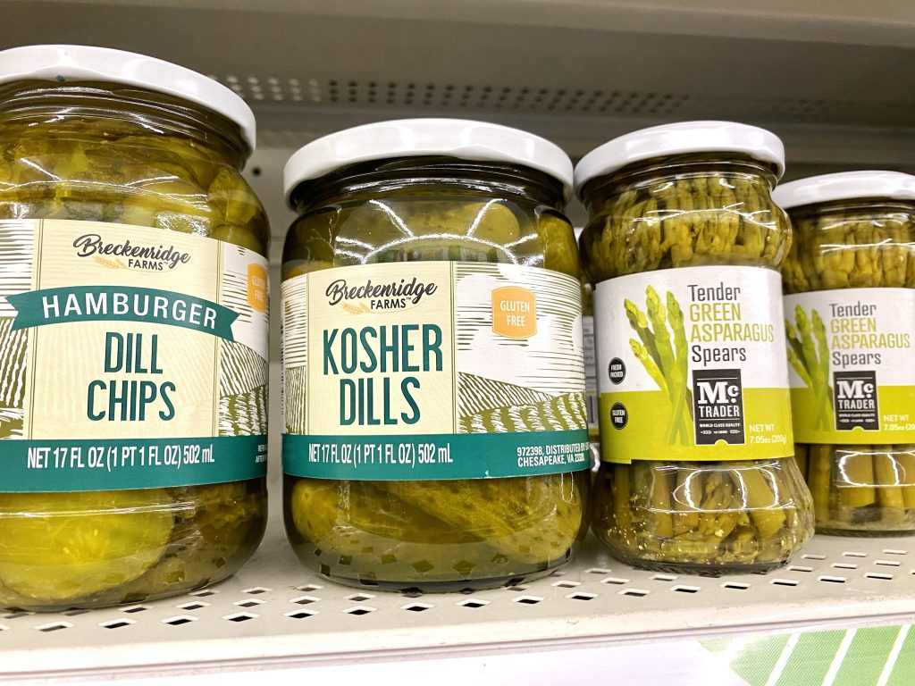 Jars of pickles on a store shelf.