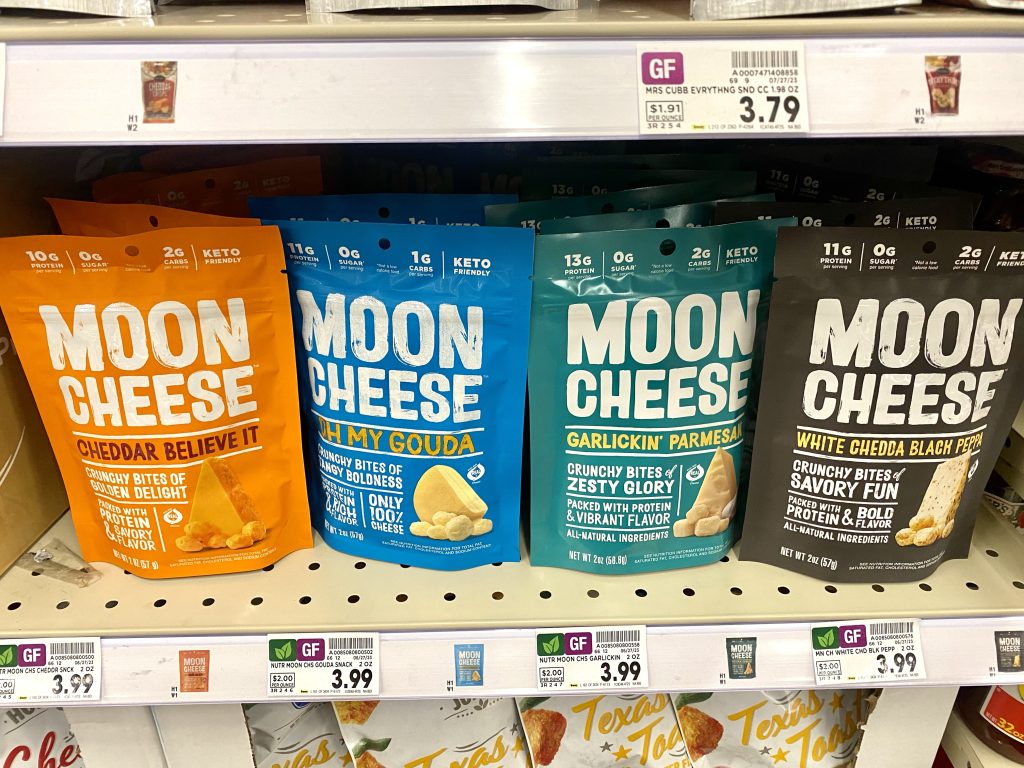A variety of flavors of moon cheese on store shelf.