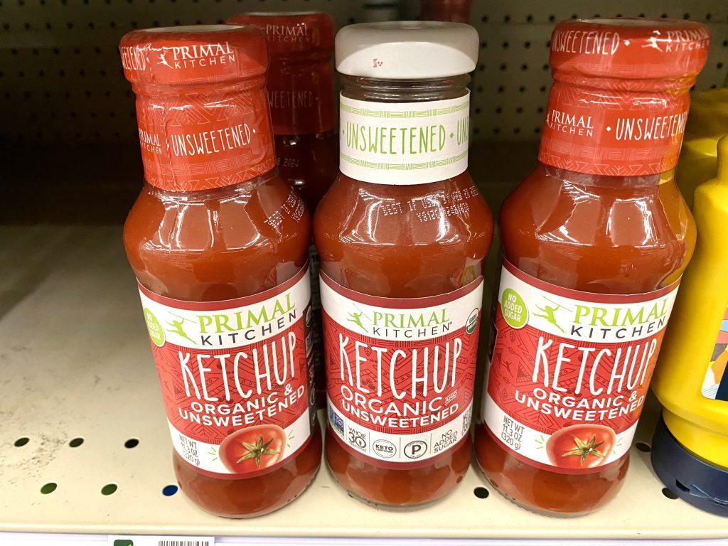 Bottles of sugar free ketchup on store shelf.