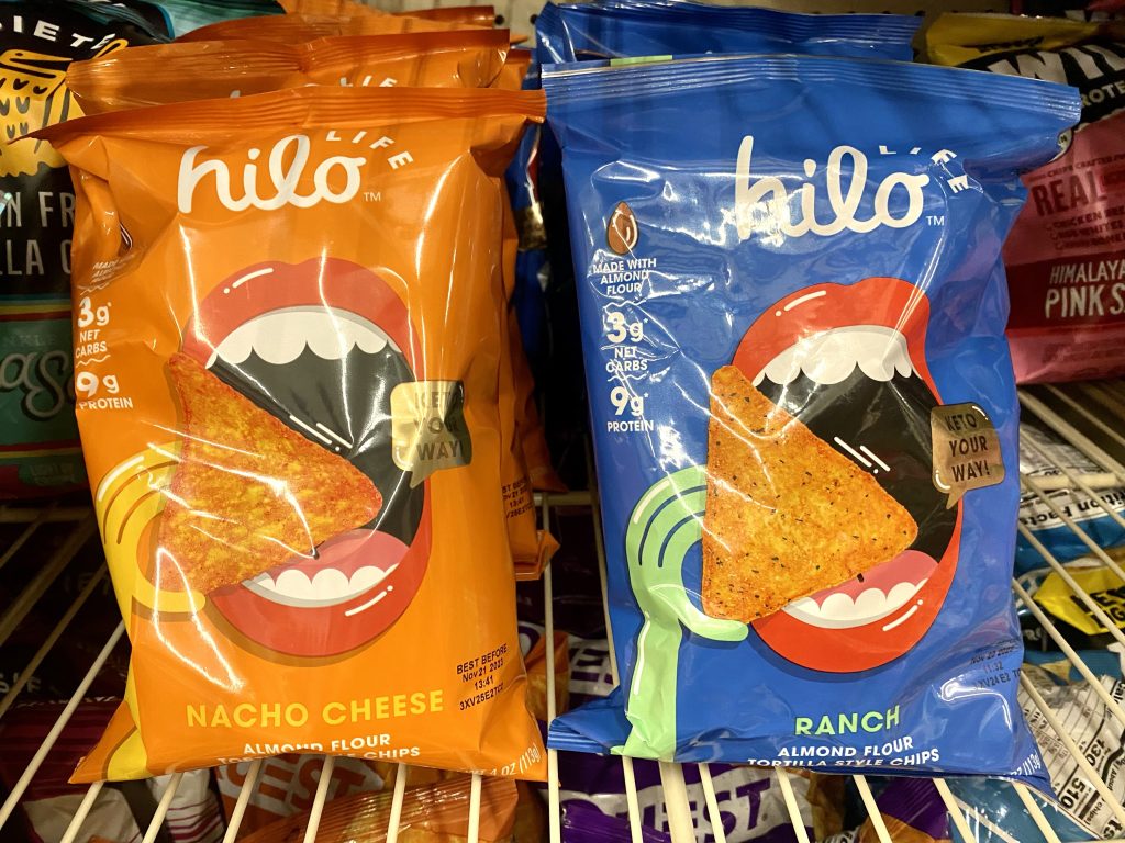 Packages of Hilo Low Carb Chips on a store shelf.