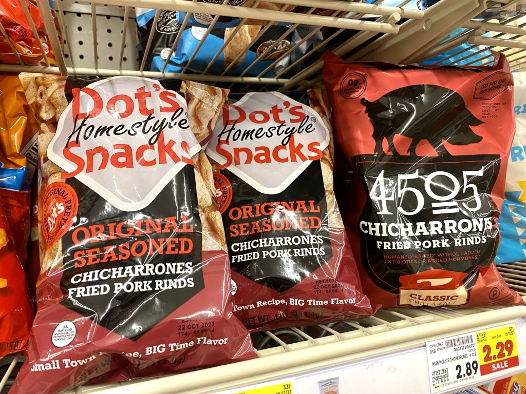 Bags of pork rinds on store shelf.