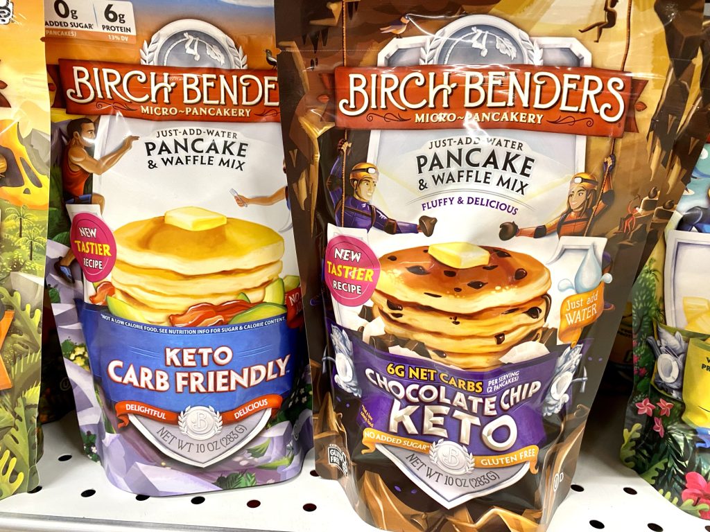 Packages of keto pancakes on store shelf.