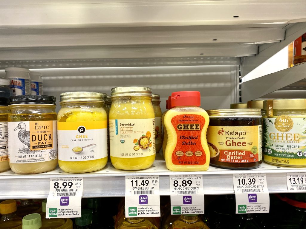 A variety of brands of ghee on grocery store shelf.