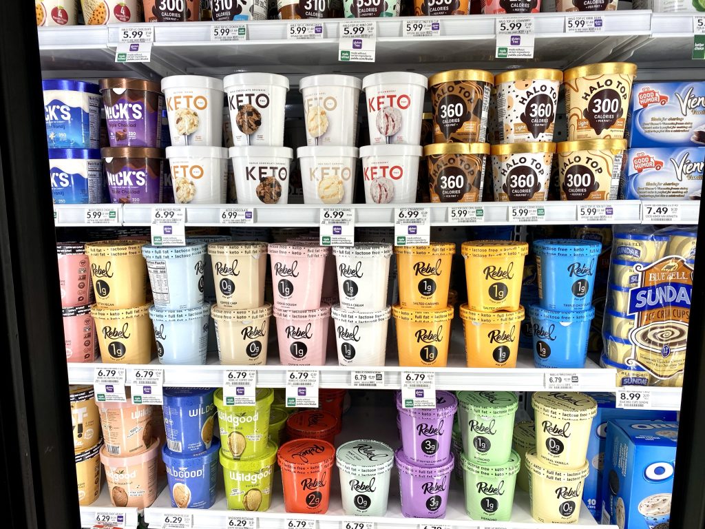 A variety of keto ice creams in the freezer section of grocery store.